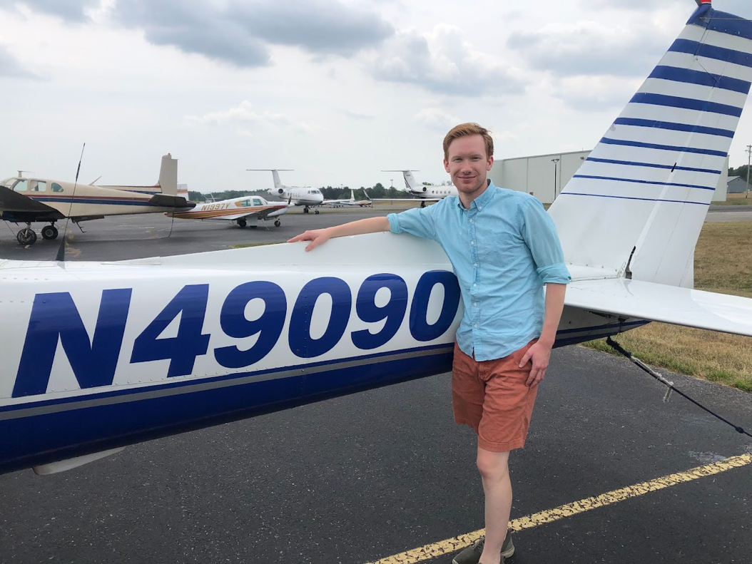 Christopher Aselin standing beside a general aviation aircraft