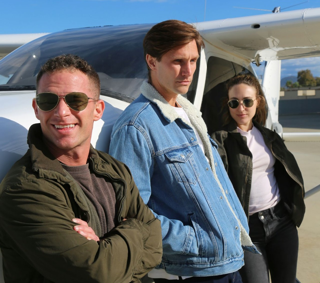 Pilots and students standing near a general aviation aircraft